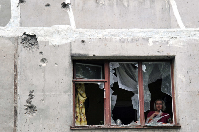 A resident is seen through her window on July 9, 2014 inside her apartment, in a building damaged the day before by Ukrainian forces' mortar fire, in Lugansk, eastern Ukraine. (AFP Photo)