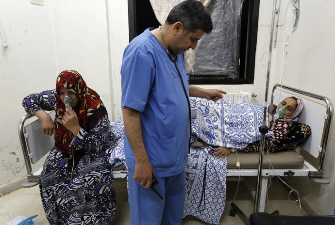 Women, affected by what activists say was a gas attack, receive treatment inside a makeshift hospital in Kfar Zeita village in the central province of Hama May 22, 2014. (Reuters/Badi Khlif)