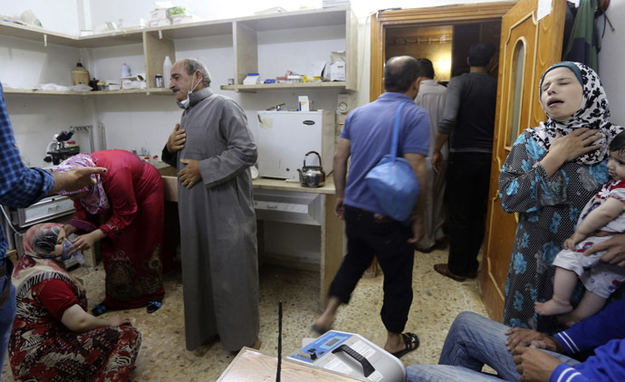 A woman (L), affected by what activists say was a gas attack, breathes through an oxygen mask inside a hospital in Kfar Zeita village in the central province of Hama May 19, 2014. (Reuters/Badi Khlif)