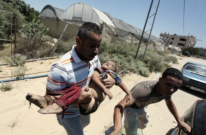 People carry the body of a Palestinian boy whom hospital officials said was killed in an Israeli air strike on his family's house, in Gaza city July 9, 2014. (Reuters)