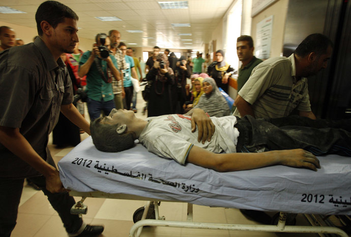 Palestinians wheel a stretcher carrying a boy, who hospital officials said was wounded in an Israeli air strike on a house, in Gaza City July 9, 2014. (Reuters)