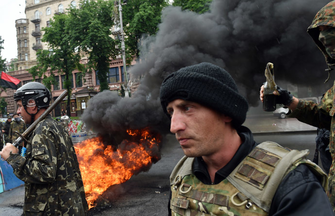 Protesters from Kiev's Independence Square, the so-called "Maidan", hold a metal bar and a petrol bomb as they burn tyres to protect their barricades from being dismantled by communal services on May 31, 2014 in the centre of Kiev. (AFP Photo)