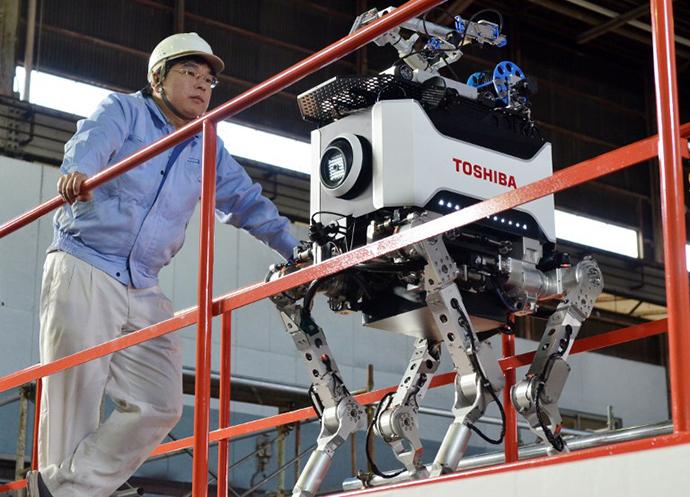 Engineers inspect Toshiba's four-legged robot during a demonstration at Toshiba's technical center in Yokohama, suburban Tokyo on November 21, 2012. (AFP Photo / Yoshikazu Tsuno)