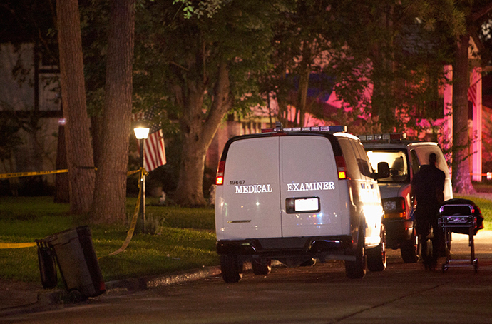 A Harris County Medical Examiner prepares to place a body into the coroner's van as they remove bodies from a home after several people were shot to death, in the Houston suburb of Spring, in Texas early July 10, 2014 (Reuters / Daniel Kramer)