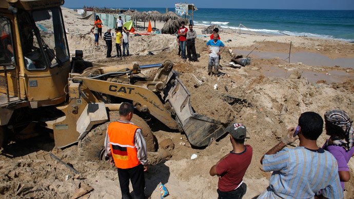 Palestinians use a bulldozer to remove debris of a beach cafe hit last night by an Israeli air strike while people were watching the World Cup semi-final football match, on July 10, 2014 in the southern Gaza Strip city of Khan Yunis.(AFP Photo / Thomas Coex)