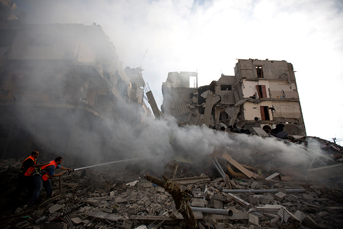 Palestinian firefighters extinguish fire from a building following an Israeli air strike in Gaza City on July 11, 2014 (AFP Photo / Mohammed Abed)