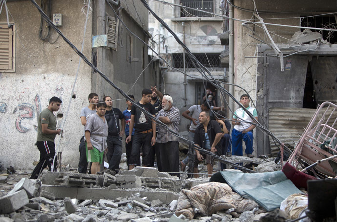 Palestinian men inspect the destruction following an Israeli military strike in Gaza City on July 12, 2014. (AFP Photo)