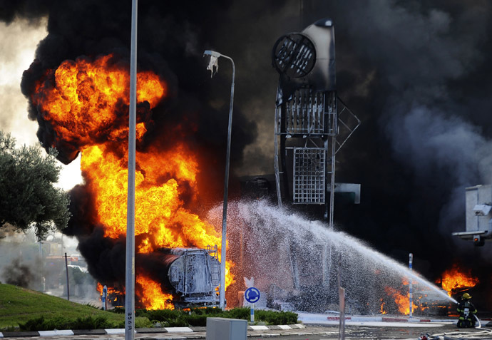 Israeli firefighters extinguish a fire that broke out after a rocket hit a petrol station in the southern Israeli city of Ashdod July 11, 2014. (Reuters/Avi Roccah)