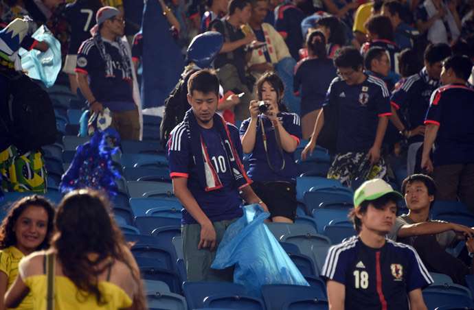 Japanese fan clean the tribune after a Group C football match between Japan and Greece at the Dunas Arena in Natal during the 2014 FIFA World Cup on June 19, 2014. (AFP Photo/Toshifumi Kitamura)