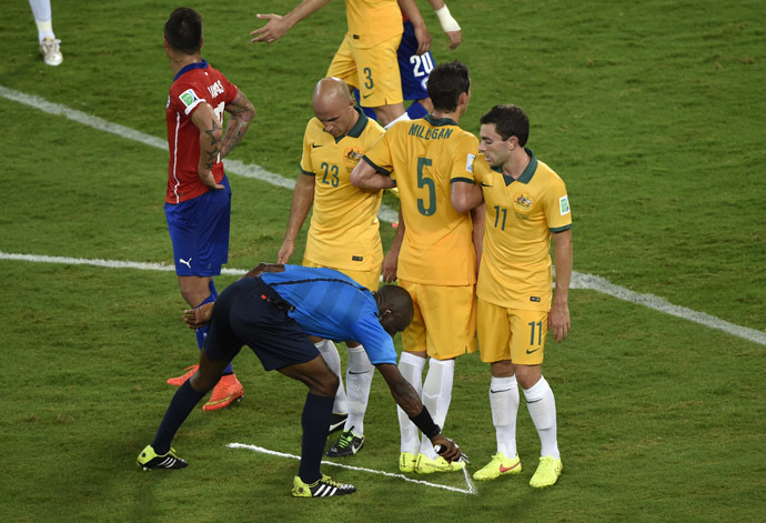 Ivorian referee Noumandiez Desire Doue uses his freekick spray marker during a Group B football match between Chile and Australia at the Pantanal Arena in Cuiaba during the 2014 FIFA World Cup on June 13, 2014. (AFP Photo/Juan Barreto)