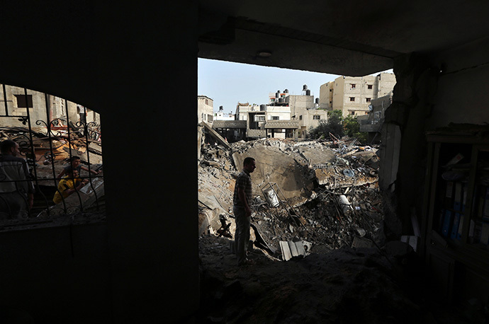 Palestinians survey the rubble of a house which police said was destroyed in an Israeli air strike in the northern Gaza Strip July 12, 2014. (Reuters / Mohammed Salem) 