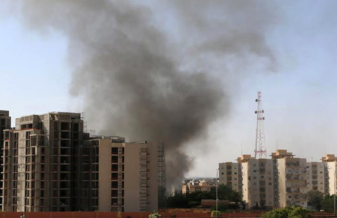 Smoke rises near buildings after heavy fighting between rival militias broke out near the airport in Tripoli July 13, 2014. (Reuters)