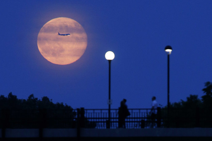 Aircraft passes in front of a Supermoon rising over the Rideau Canal in Ottawa July 12, 2014. (Reuters/Blair Gable)