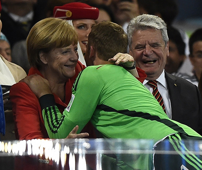 Germany's goalkeeper Manuel Neuer receives a hug from Chancellor Angela Merkel beside President Joachim Gauck (R) after the 2014 World Cup final between Germany and Argentina at the Maracana stadium in Rio de Janeiro July 13, 2014. (Reuters / Dylan Martinez)