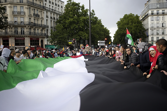 Protesters hold a large Palestinian flag on July 13, 2014 in Paris, during a demonstration against Israel and in support of residents in the Gaza Strip. (AFP Photo / Kenzo Tribouillard)