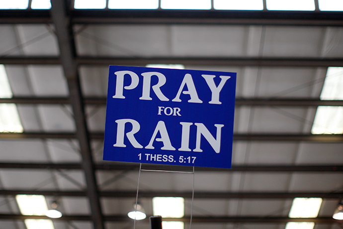 A sign advising to pray for rain hangs above an exhibit area at the 47th Annual World Ag Expo in Tulare, California (Reuters / David McNew)