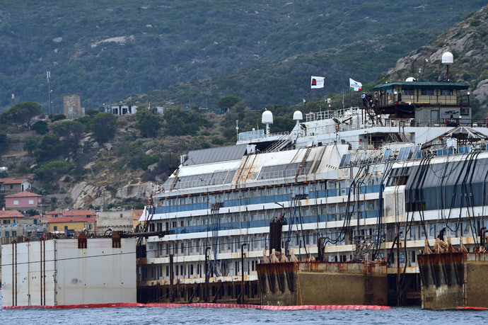 A picture shows the wreck of the Costa Concordia cruise ship starting being lifted out of water during an operation to refloat the boat on July 14, 2014 off the Giglio Island. (AFP Photo / Giuseppe Cacace) 