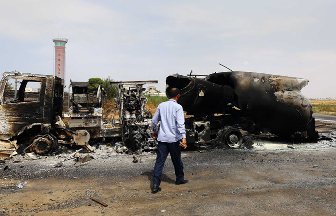 The wreckage of a truck and an airplane are seen at Tripoli international airport in the Libyan capital on July 14, 2014 following fighting between rival armed groups the previous day. (AFP Photo / Mahmud Turkia)