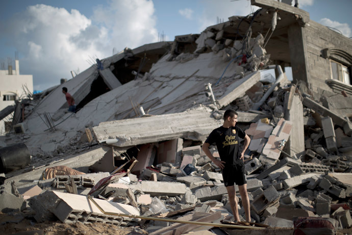 A Palestinian man stands on the rubble of a destroyed building following an Israeli military strike on Beit Lahya, in the northern Gaza Strip on July 15, 2014. (AFP Photo / Mahmud Hams)