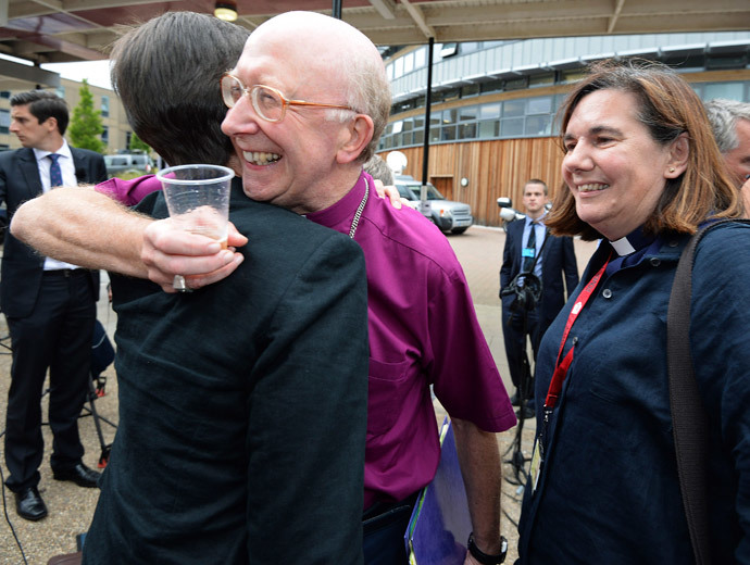 Bishop of Oxford John Pritchard (C) hugs a female member of the clergy after the Synod session which approved the consecration of women bishops, in York July 14, 2014. (Reuters / Nigel Roddis)