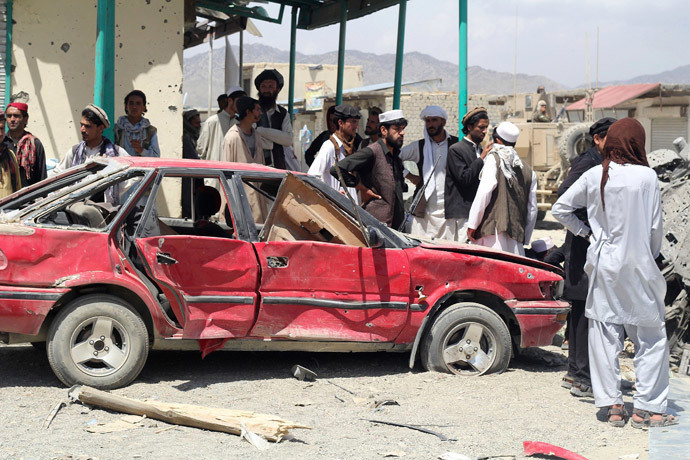 Villagers gather at the site of a car bomb attack in Urgon district, eastern province of Paktika July 15, 2014. (Reuters / Stringer)