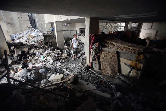 A Palestinian inspects a charitable organization which police said was targeted in an Israeli air strike in Rafah in the southern Gaza Strip July 15, 2014. (Reuters / Ibraheem Abu Mustafa)