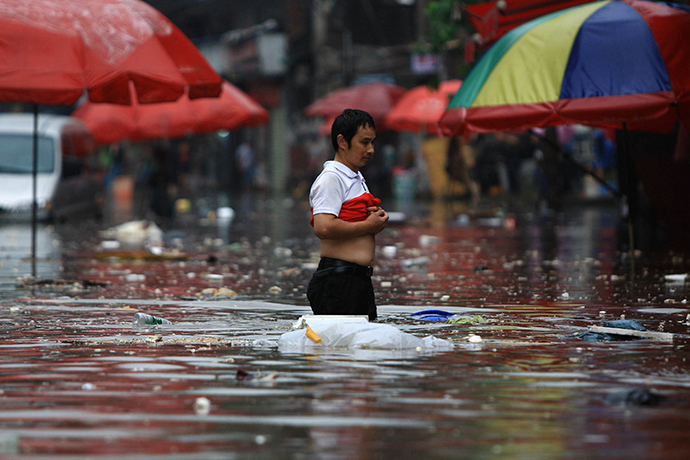 A man makes his way through a flooded area in Changsha, central China's Hunan province, on July 15, 2014 (AFP Photo)