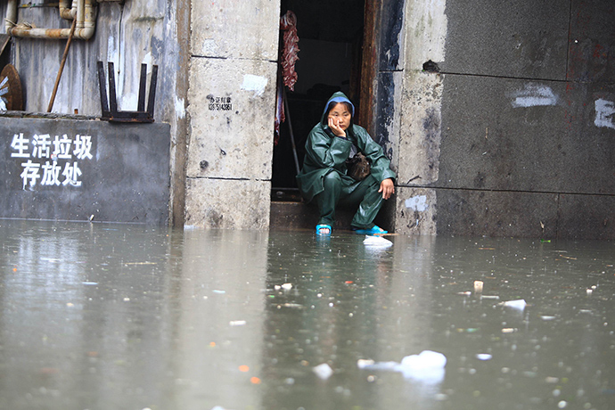 A woman looks on at a flooded area in Changsha, central China's Hunan province, on July 15, 2014 (AFP Photo)