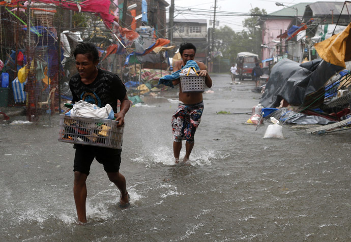 Residents carry their belongings as Typhoon Rammasun (locally named Glenda) hit the town of Imus, Cavite southwest of Manila, July 16, 2014. (Reuters)