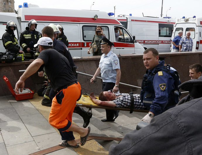 Members of the emergency services carry an injured passenger outside a metro station following an accident on the subway in Moscow July 15, 2014. (Reuters/Sergei Karpukhin)