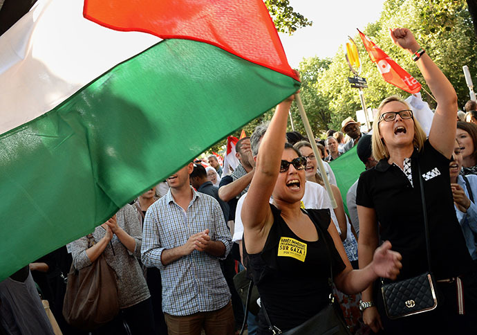 A woman holds a Palestinian flag as she protests on July 16, 2014 with others on the central Invalides square in Paris against Israel's deadly bombing of Gaza. (AFP Photo / Pierre Andrieu)