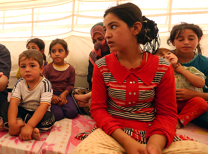 Young displaced Iraqis at the Khazer camp for Iraqi family fleeing violence following last month's jihadist-led offensive on July 17, 2014, at the Kurdish checkpoint in Aski kalak, 40 km West of Arbil, the capital of the autonomous Kurdish region of northern Iraq. (AFP Photo / Safin Hamed)