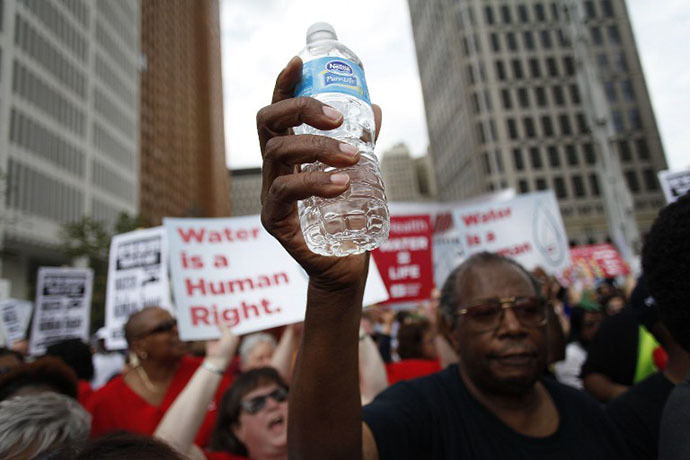 A man holds a bottle of water as he joins other demonstrators protesting against the Detroit Water and Sewer Department July 18, 2014 in Detroit, Michigan. (AFP Photo / Joshua Lott)