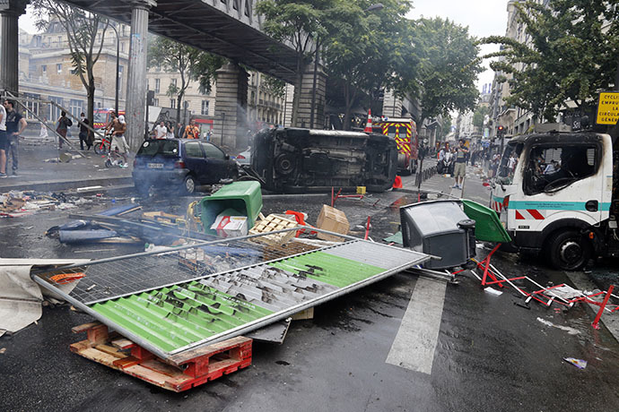 Burned vehicles owned by Paris public services are seen by the aerial metro station of Barbes-Rochechouart, in Paris, on July 19, 2014, during clashes between French riot police and protesters in the aftermath of a demonstration, banned by French police, to denounce Israel's military campaign in Gaza and show support to the Palestinian people. (AFP Photo / Francois Guillot)