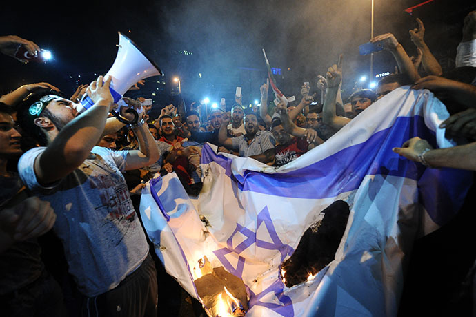 Turkish protestors set fire to Israel flag while they are shout slogans during a demonstration to denounce the Israeli military operations in Gaza on July 19, 2014 in front of the Israeli Consulate in Istanbul. (AFP Photo / Ozan Kose)