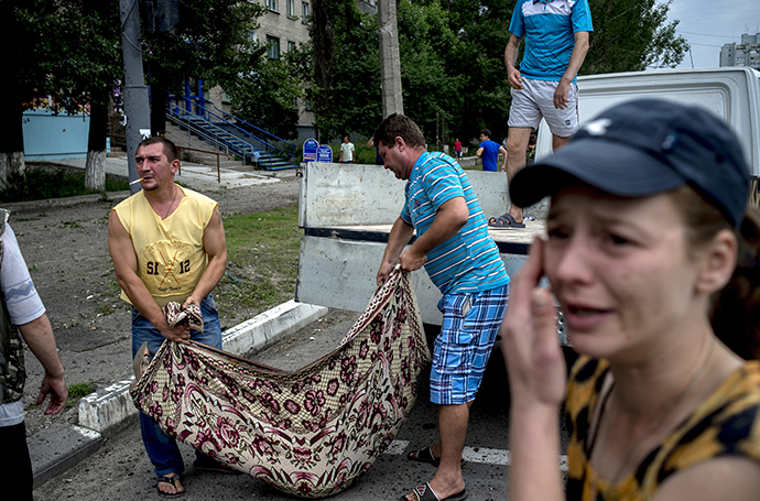 People in Lugansk carry the bodies of those killed during an artillery attack on the city on July 18, 2014. (RIA Novosti / Valeriy Melnikov)