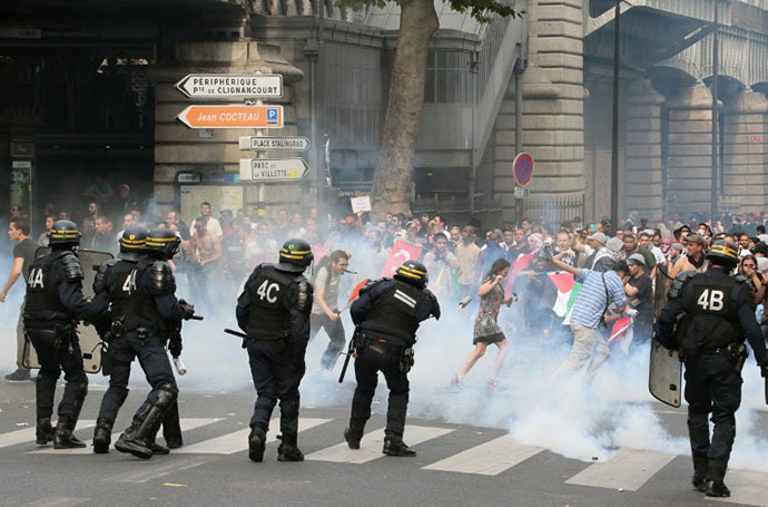 Protesters run away from tear gas as they clash with riot police near the Barbes-Rochechouart aerial metro station in Paris on July 19, 2014. (AFP Photo / Jacques Demarthon)
