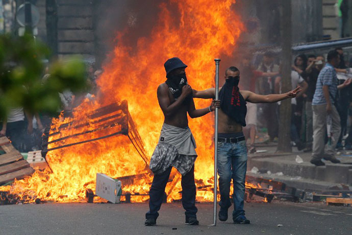 Protesters stand in front of a fire barricade near the aerial metro station of Barbes-Rochechouart, in Paris, on July 19, 2014. (AFP Photo / Francois Guillot)