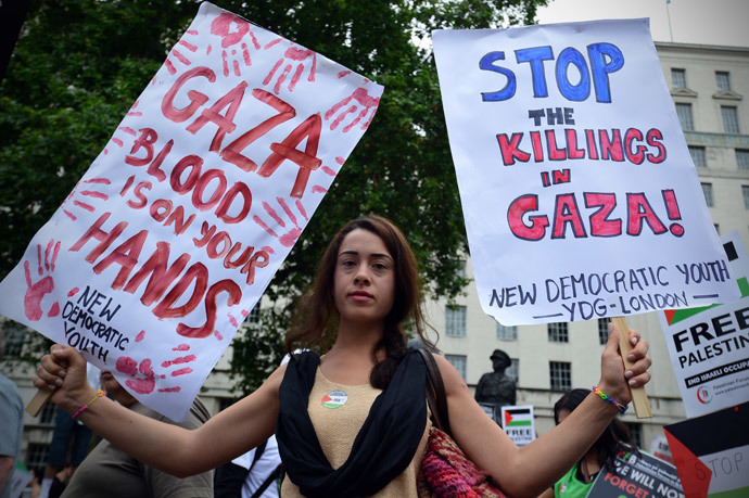 A protestor displays banners as she takes part in demonstration against Israeli airstrikes in Gaza in central London on July 19, 2014 against Gaza strikes. (AFP Photo / Carl Court)