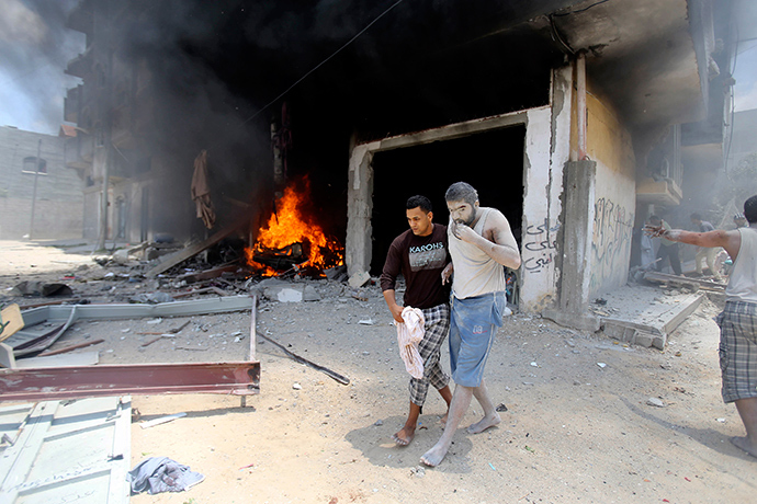 A Palestinian evacuates a wounded man following what police said was an Israeli air strike on a house in Rafah in the southern Gaza Strip July 20, 2014 (Reuters / Ibraheem Abu Mustafa)