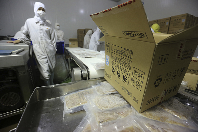 Employees work at a production line prior to a seizure conducted by officers from the Shanghai Food and Drug Administration, at the Husi Food factory in Shanghai, July 20, 2014. (Reuters)