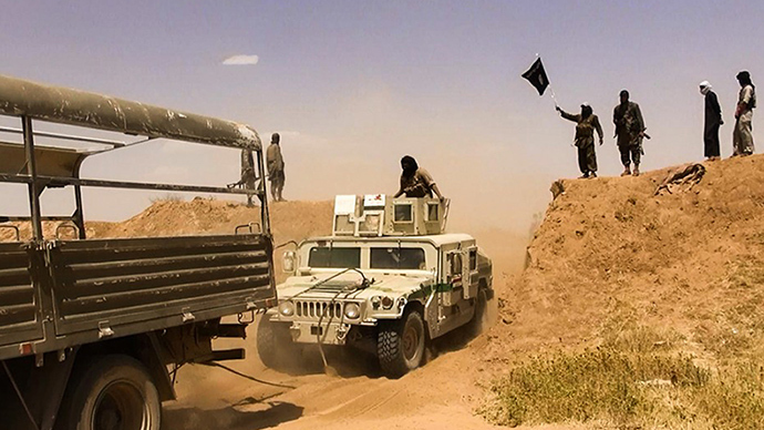 A file image made available by the jihadist Twitter account Al-Baraka news on June 9, 2014 allegedly shows Islamic State of Iraq and the Levant (ISIL) militants waving the trademark Jihadits flag as vehicles drive on a newly cut road through the Syrian-Iraqi border between the Iraqi Nineveh province and the Syrian town of Al-Hasakah (AFP Photo)