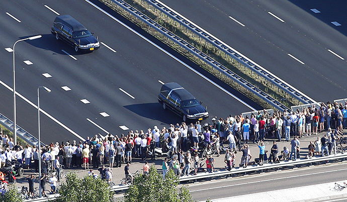 This aerial photo shows people watching from a bridge a convoy of hearses carrying coffins containing the remains of victims of the downed Malaysia Airlines flight MH17, driving from the Eindhoven Airbase to Hilversum on July 23, 2014. (AFP Photo / Jerry Lampen)