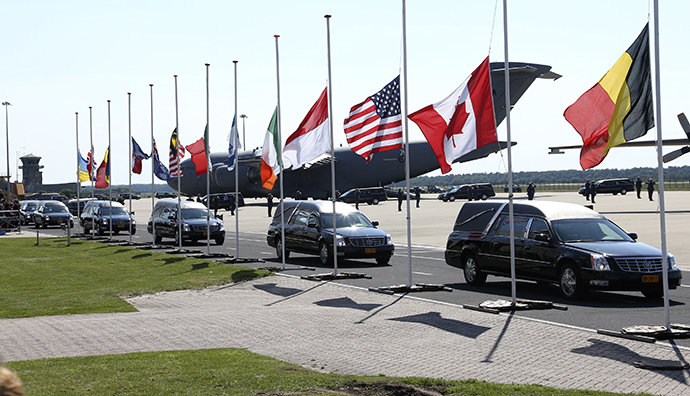 The convoy of hearses with the remains of the victims of Malaysia Airlines MH17 downed over rebel-held territory in eastern Ukraine, drives past international flags as it leaves Eindhoven airport to a military base in Hilversum July 23, 2014. (Reuters / Francois Lenoir)