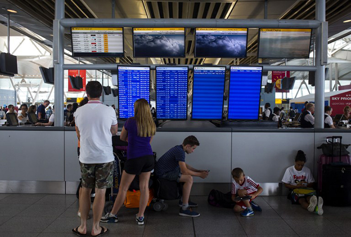 People stand in the Delta Airlines terminal at John F. Kennedy Airport July 22, 2014 in New York City. (AFP Photo / Getty Images / Eric Thayer)