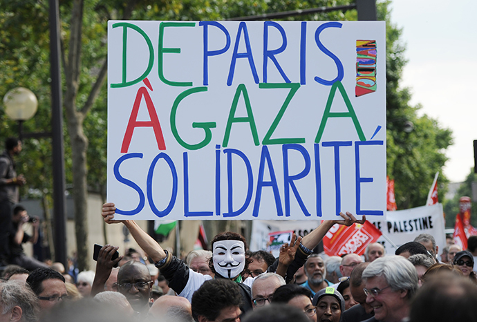 A man holds a placard reading "From Paris to Gaza, Solidarity", as protesters take part in a demonstration on July 23, 2014 in front of the Invalides in Paris, to denounce Israel's military campaign in Gaza and to show their support to the Palestinian people (AFP Photo / Stephane De Sakutin)