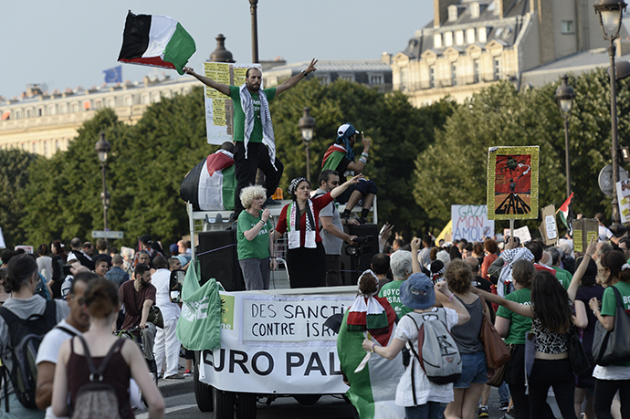 Protesters wave Palestinian flags as they stand on a vehicle during a demonstration on July 23, 2014 in front of the Invalides in Paris, to denounce Israel's military campaign in Gaza and to show their support to the Palestinian people (AFP Photo / Stephane De Sakutin)