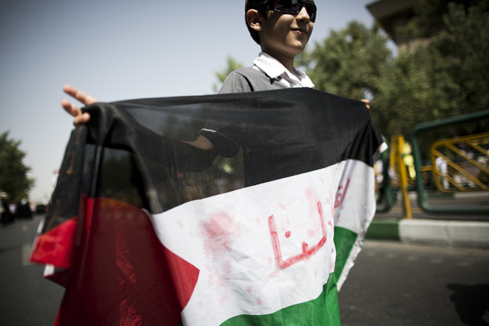 An Iranian boy holds a Palestinian flag during a demonstration in Tehran on July 25, 2014 to mark Quds (Jerusalem) Day. (AFP Photo / Behrouz Mehri)