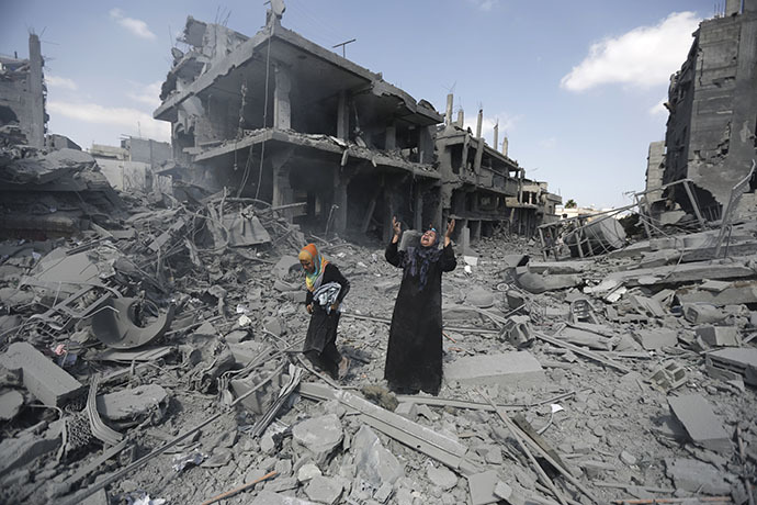 A Palestinian woman pauses amid destroyed buildings in the northern district of Beit Hanun in the Gaza Strip during an humanitarian truce on July 26, 2014. (AFP Photo / Mohammed Abed)
