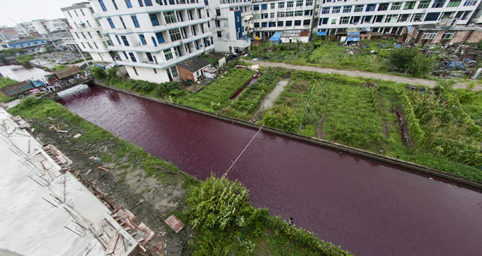 This picture taken on July 24, 2014 shows a river with its water turned to red in Wenzhou, east China's Zhejiang province. (AFP Photo/China Out)